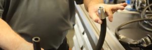 person holding hydraulic hose assembly